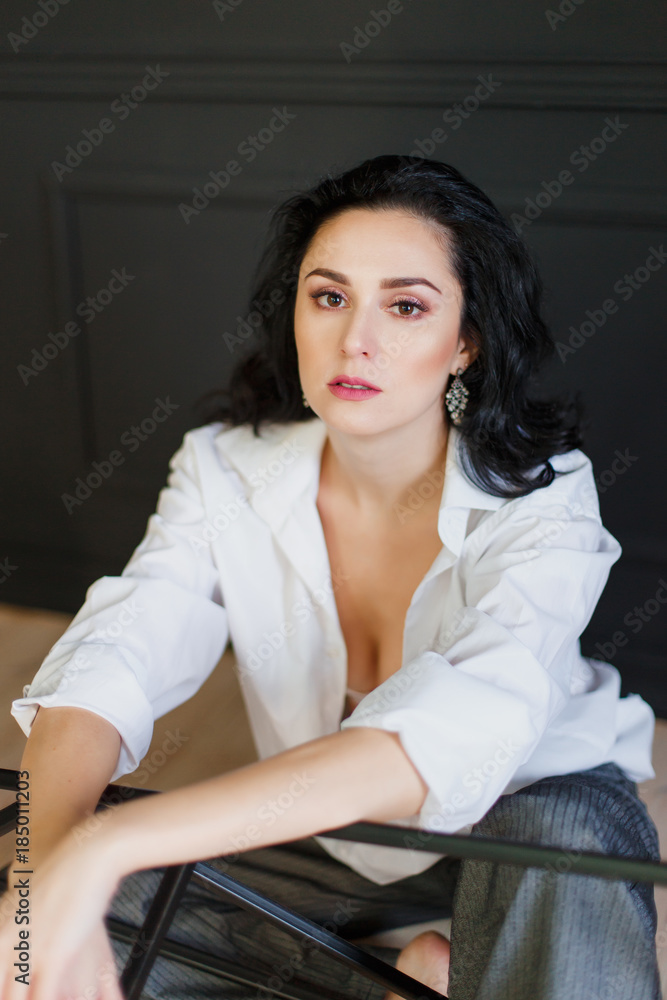 beautiful business woman in studio. is casually dressed in a shirt and wide pants. portrait beautiful business woman in studio. is casually dressed in a shirt and wide pants. portrait