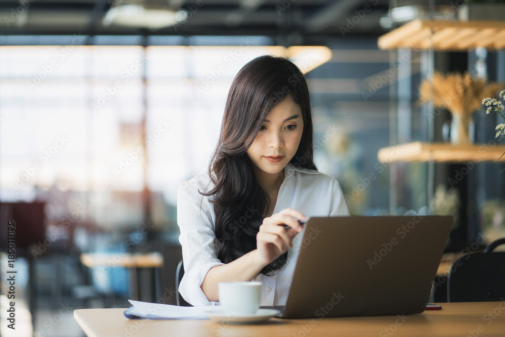 Young business woman using on the laptop while sitting at her working place. Young business woman using on the laptop while sitting at her working place.