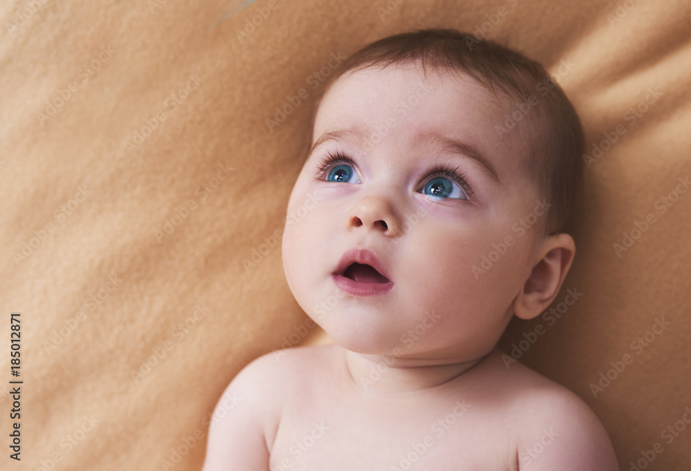 Portrait of a smiling crawling baby on the bed in her room. Space for text Portrait of a smiling crawling baby on the bed in her room. Space for text