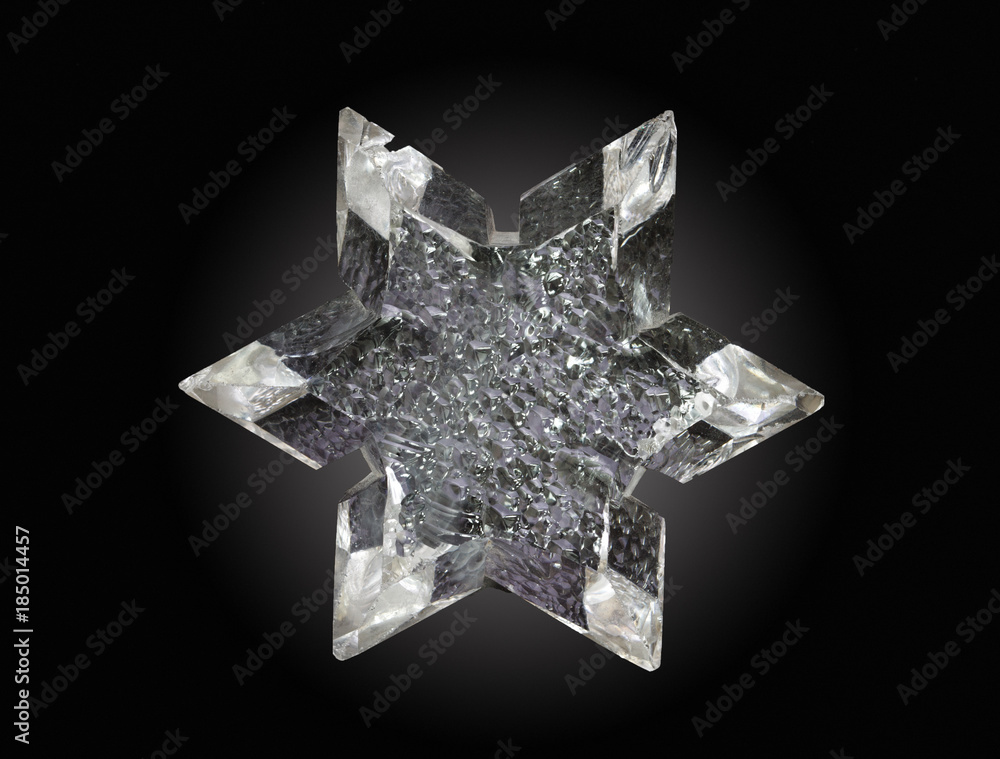 Synthetically grown in autoclave the quartz crystal in the form of a six-pointed star on black background Synthetically grown in autoclave the quartz crystal in the form of a six-pointed star on black background