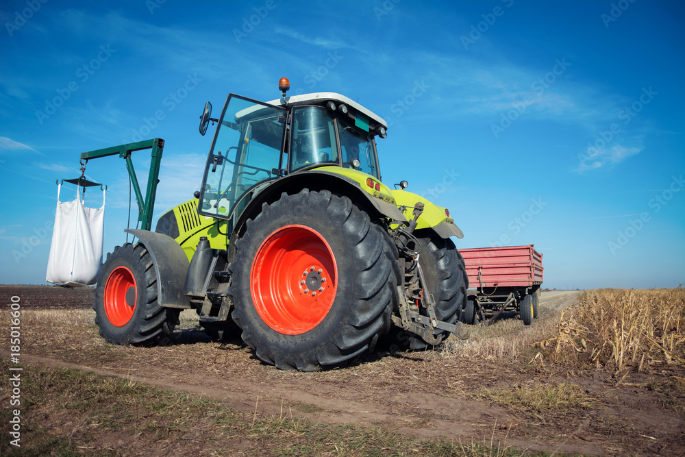Modern tractor working in a field on a sunny day. Agricultural machinery during planting. Modern tractor working in a field on a sunny day. Agricultural machinery during planting.