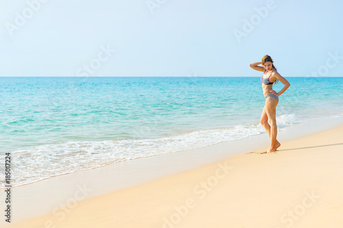 Young woman in swimwear on beautiful tropical beach.