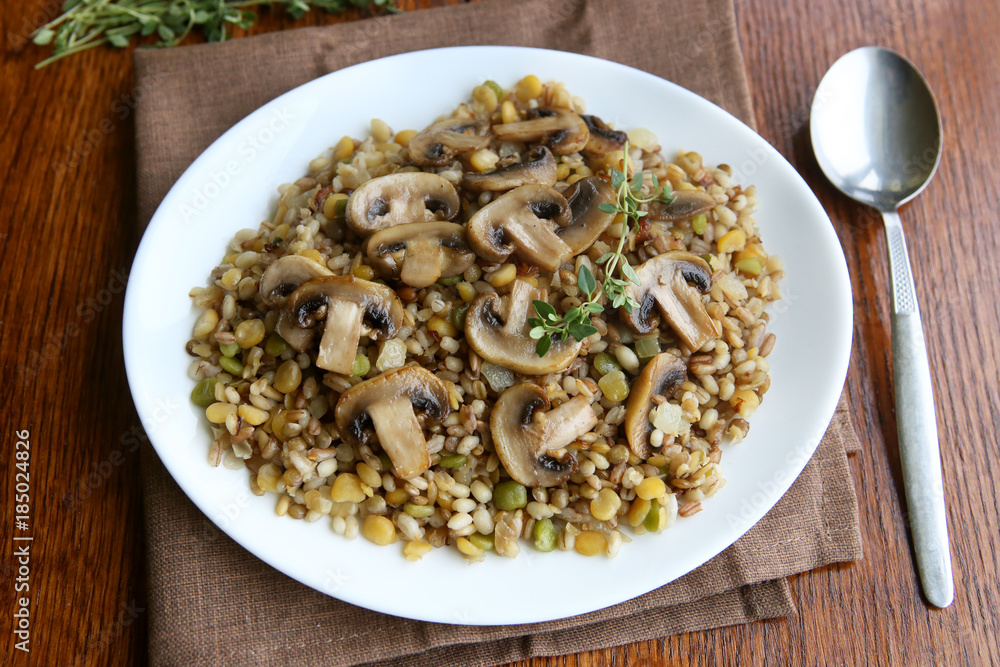 Cooked mixed grains cereal with champignon mushroom for healthy meal. Various cereals (pearl barley, oats, rye, peas, lentil) porridge in plate. Cooked mixed grains cereal with champignon mushroom for healthy meal. Various cereals (pearl barley, oats, rye, peas, lentil) porridge in plate.
