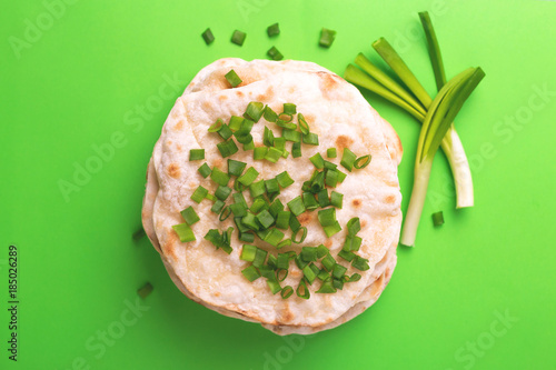 Indian flatbread chapati, green onion. Color surge trend. photo