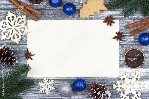 Christmas decoration card greeting, white snowflakes orange candy cane gray wooden background, blue christmas ball.