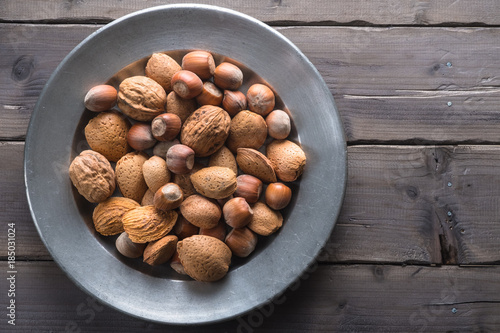 Hazelunts, walnuts and almonds on a pewter plate photo