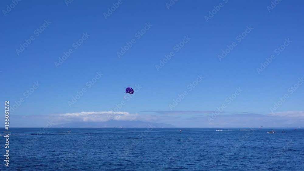 Clean sea water and clear blue sky with someones paragliding Clean sea water and clear blue sky with someones paragliding