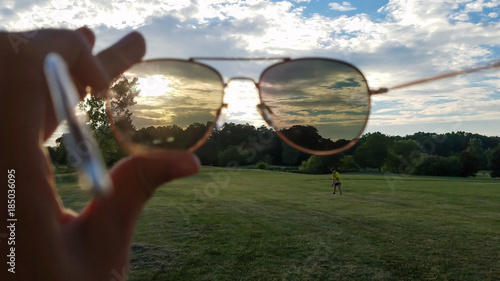 Watching golfer and sunset through sunglasses