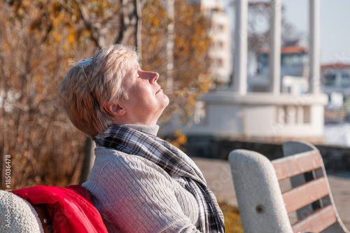Woman sitting on a bench and enjoy the sun.