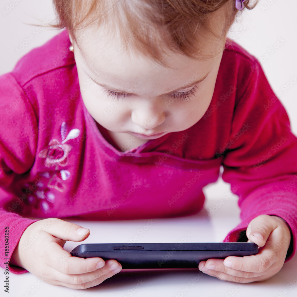 Social Media addiction. beautiful baby girl holding phone (psychological problems, media mania, education) Social Media addiction. beautiful baby girl holding phone (psychological problems, media mania, education)