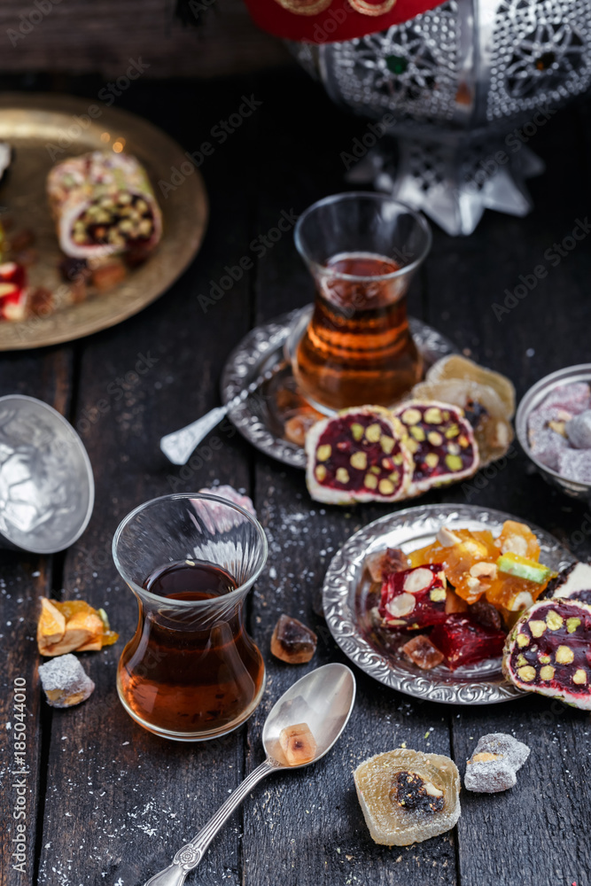 Cups of Turkish tea with oriental sweets on rustic wood
