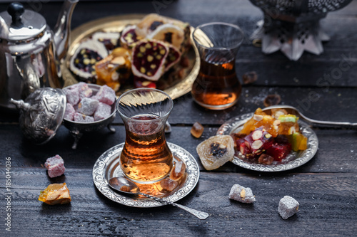 Photography Cups of Turkish tea with oriental sweets on rustic wood