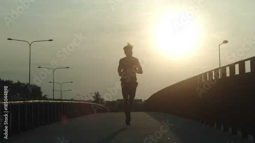 Athletic young jogger running at early morning