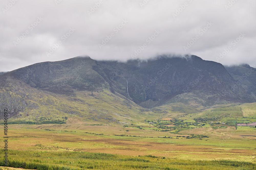 Distant view of clouds over mountain in a beautiful landscape. Ring of Kerry, Ireland.