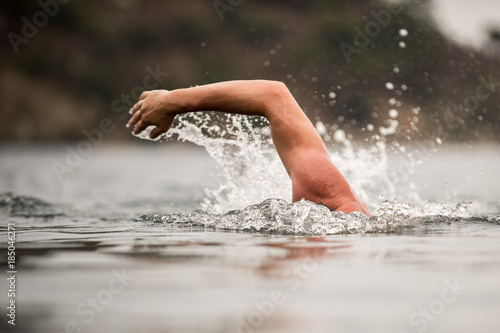 young sporting man swims in the sea