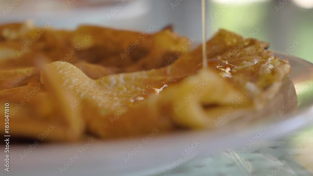 Pancakes on plate on which fruit syrup is poured. Pancakes on a plate with jam or topping. Pancakes on plate on which fruit syrup is poured. Pancakes on a plate with jam or topping.