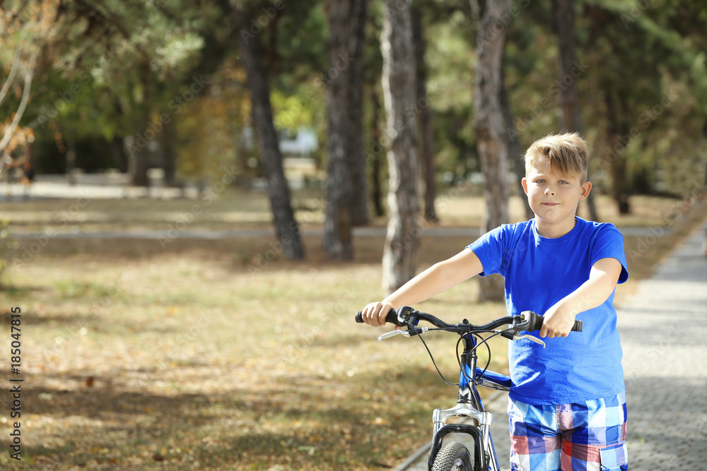 Obraz premium Overweight boy with bicycle in park