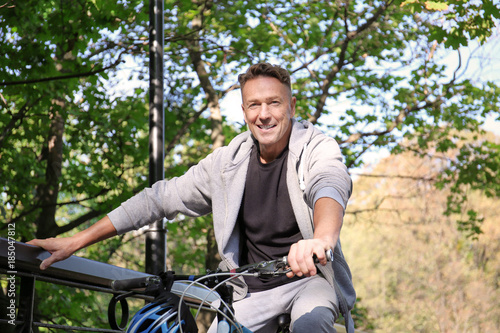 Mature sporty man with bicycle outdoors