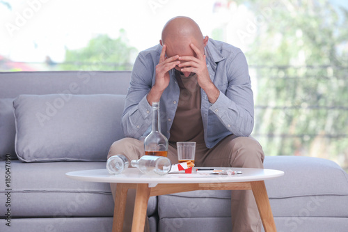 Drunk depressed man sitting...