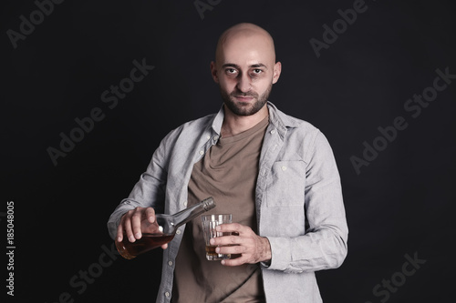 Man pouring whiskey into gl...