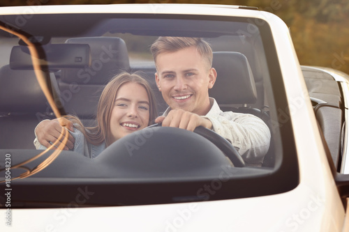 Happy young couple in car o...