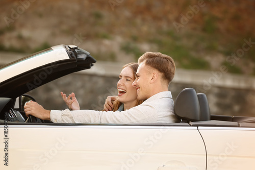 Happy young couple in car o...
