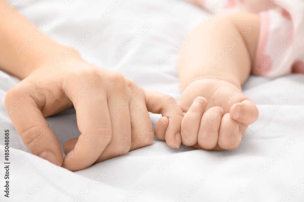 Mother holding her baby's hand, closeup