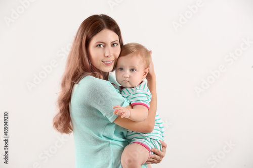 Young mother with baby on white background