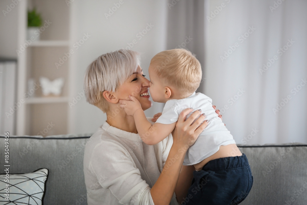 Attractive young mother with her baby on couch at home Attractive young mother with her baby on couch at home