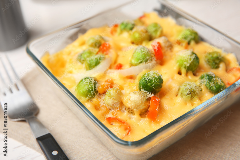 Baking dish with Brussels sprouts and cheese on table