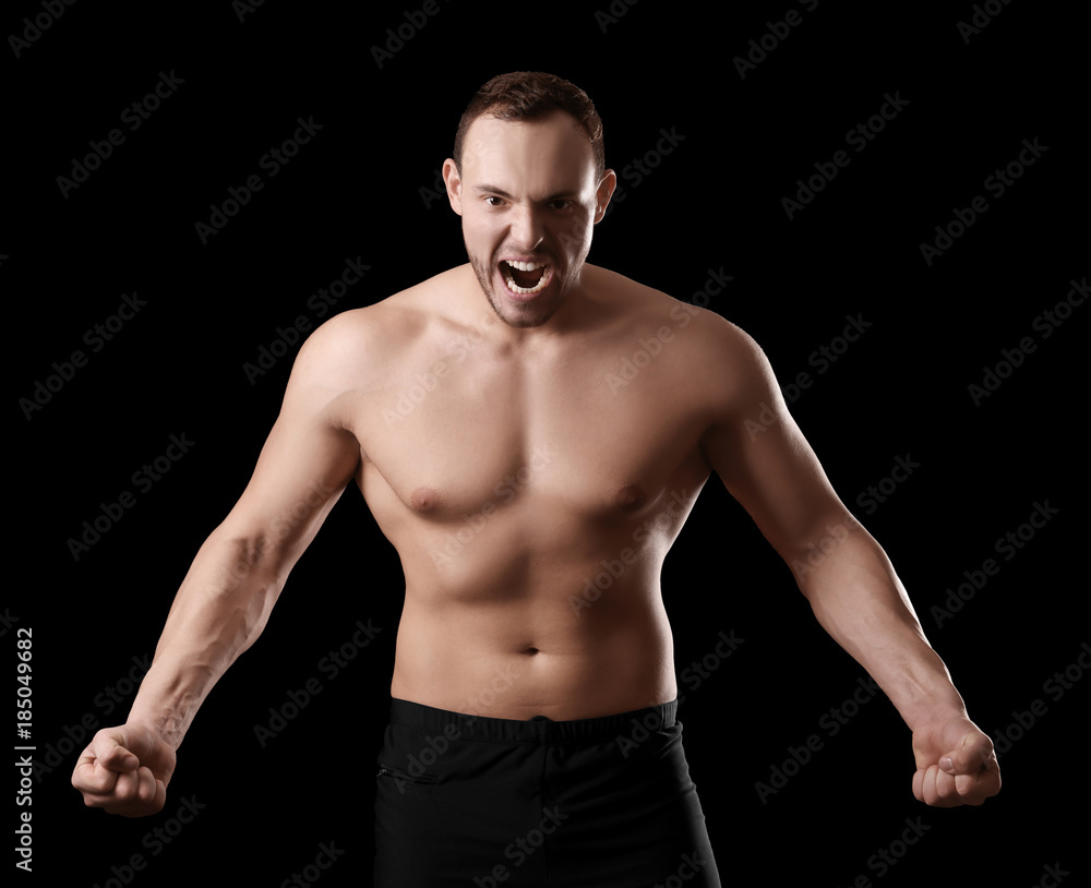 Muscular young bodybuilder on dark background Muscular young bodybuilder on dark background