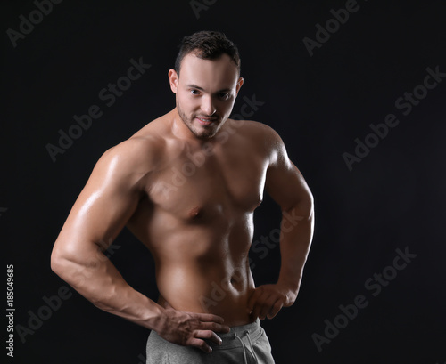 Muscular young bodybuilder on dark background © Africa Studio