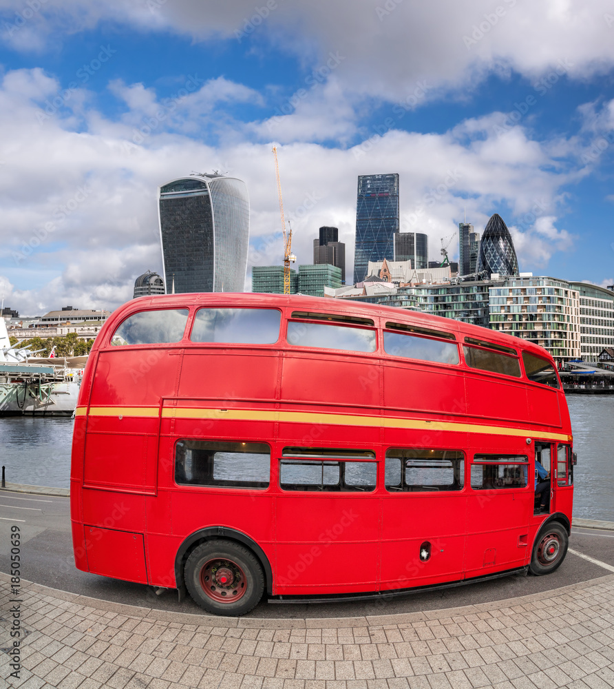 Red double decker bus with modern skyscrapers in London, England, UK