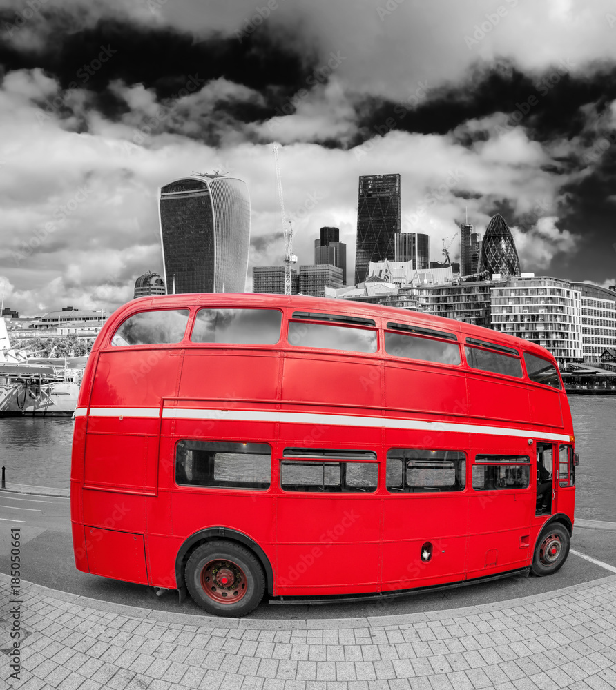 Red double decker bus with modern skyscrapers in London, England, UK