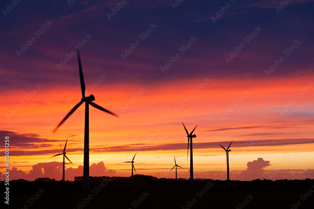 Fototapeta premium Silhouette of windturbines on an amazing sunset