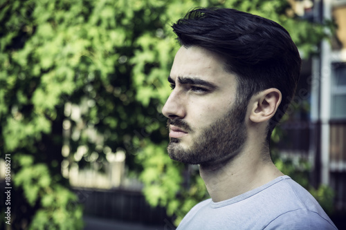 Handsome young man outdoor looking away to a side