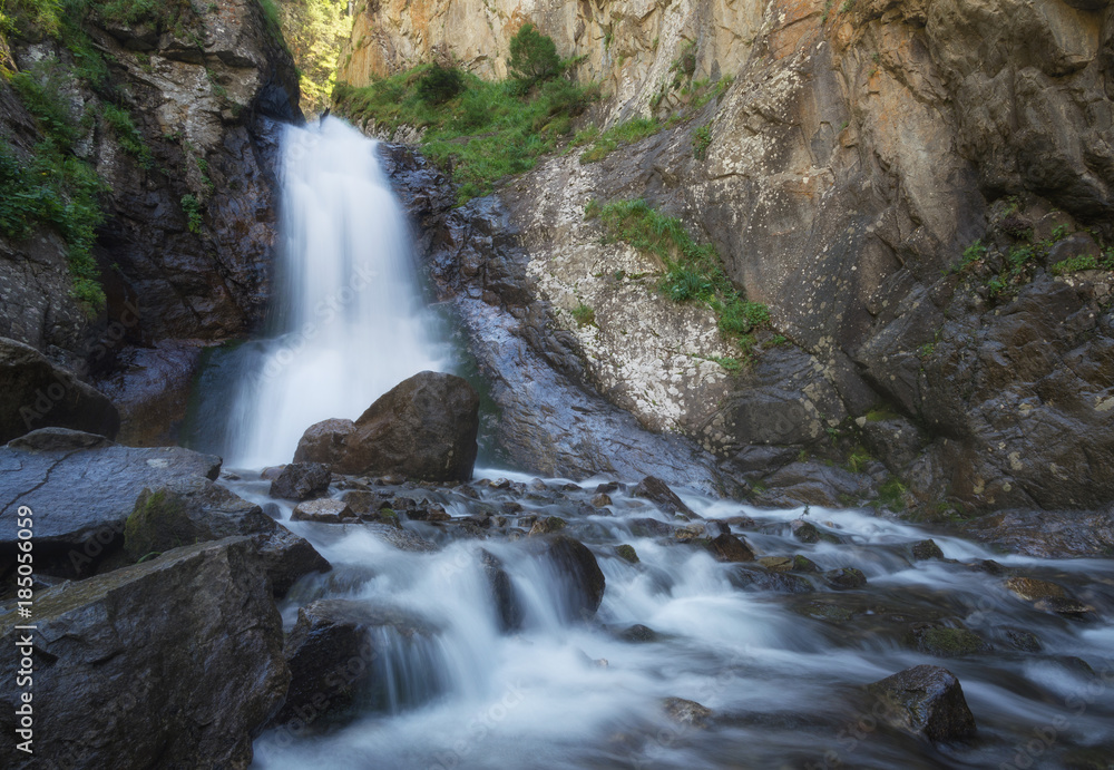 Waterfall in the canyon. Natural landscape in the summer time