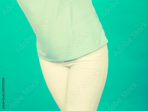 Woman hips, azure blouse shirt and white trousers