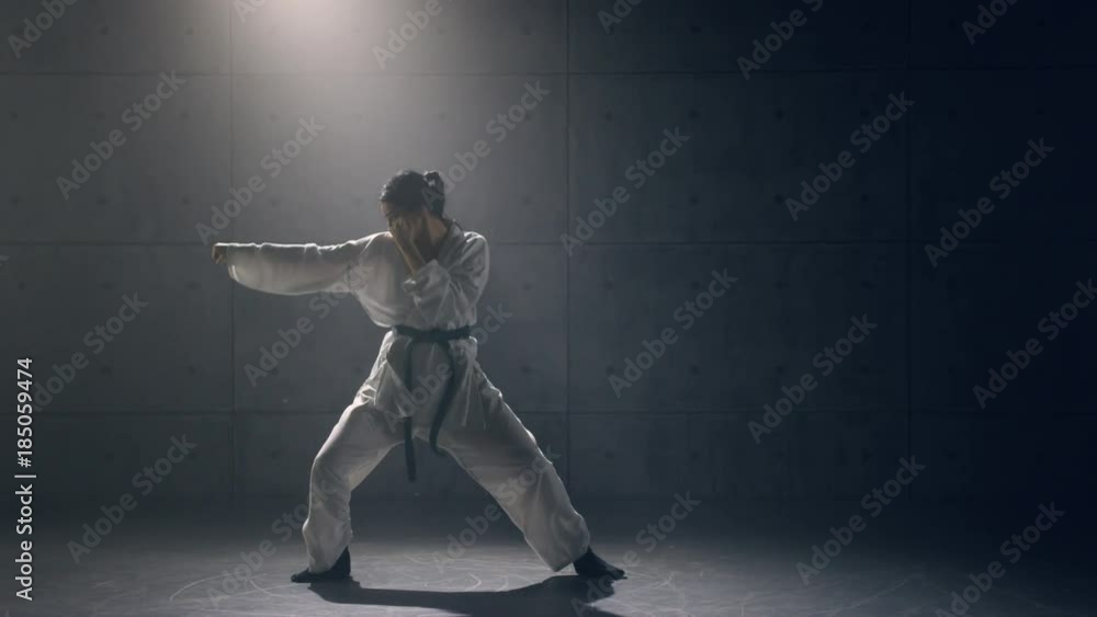 Young woman in kimono practicing karate. Slow motion Young woman in kimono practicing karate. Slow motion