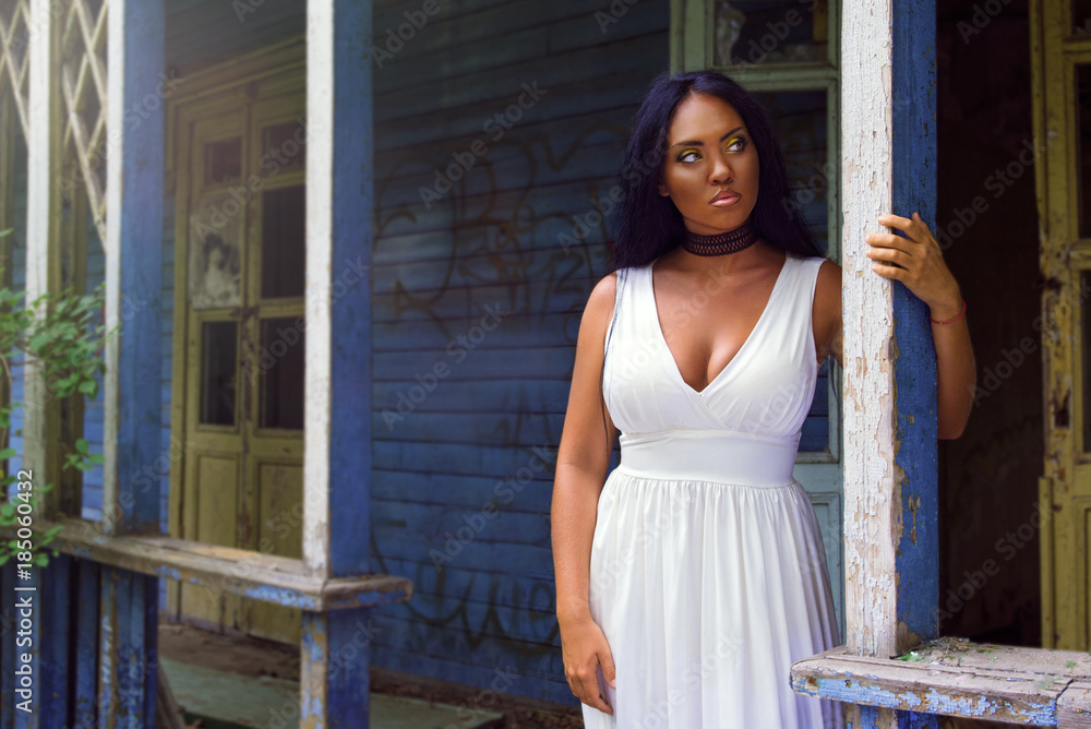Portrait of young black woman against background of an old abandoned house Portrait of young black woman against background of an old abandoned house