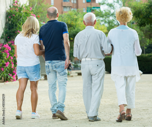 Positive group of four mature people walking