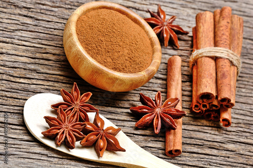 Fototapeta Naklejka Na Ścianę i Meble -  Wooden spoon with anise star and cinnamon powder with sticks on table