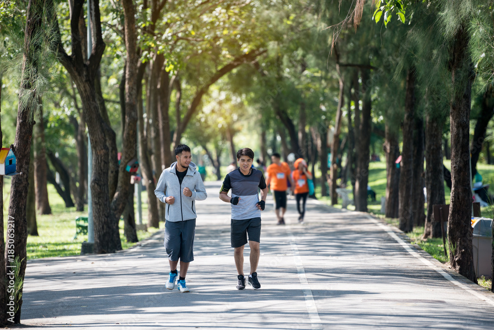 Two young fitness man running at morning in the garden, park Two young fitness man running at morning in the garden, park