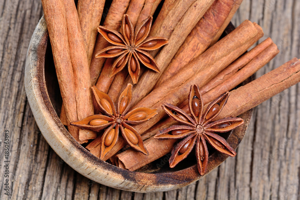 Bowl with cinnamon sticks and anise star on rustic table Bowl with cinnamon sticks and anise star on rustic table