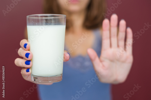 Ótimo conceito de intolerância a lactose, leite. Jovem mulher negando copo de leite. photo