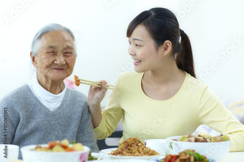 young asian woman having meal with her grandmother