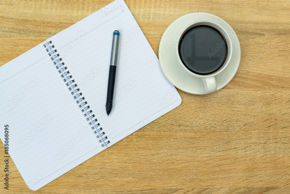 A cup of coffee with note and pen on working table with copy space top view. A cup of coffee with note and pen on working table with copy space top view.