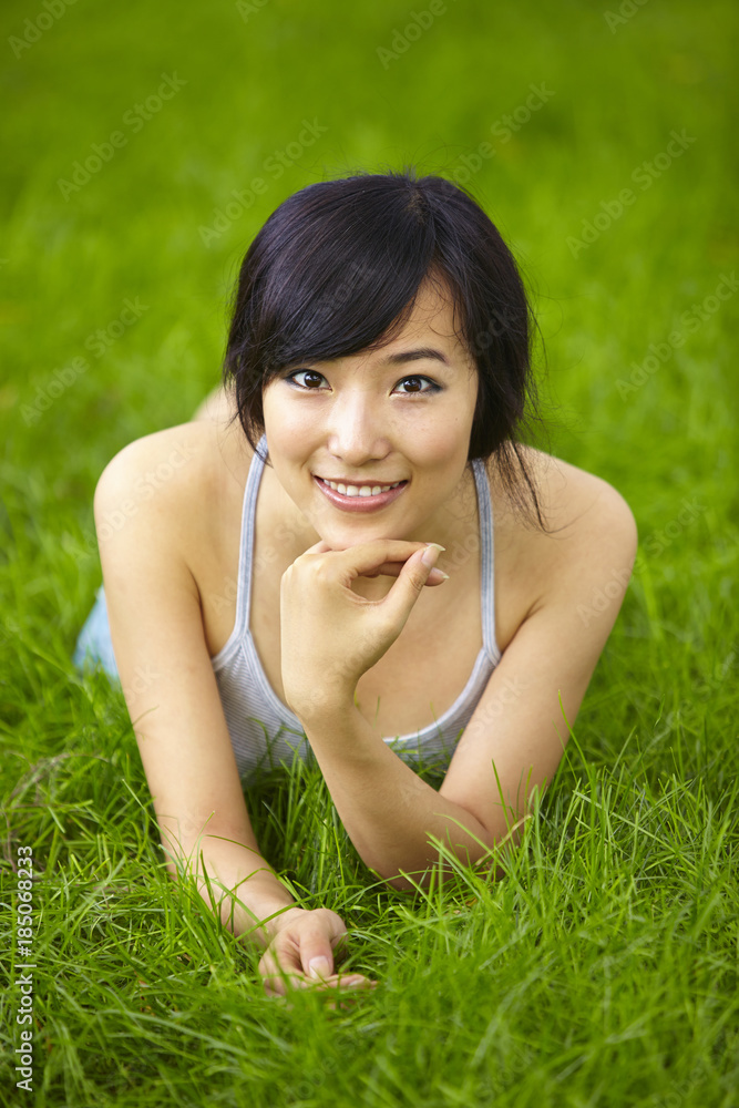 pretty young asian woman relax on grassland pretty young asian woman relax on grassland