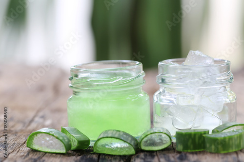 Fresh aloe vera and jelly in Glass bottle placed on a wooden floor.