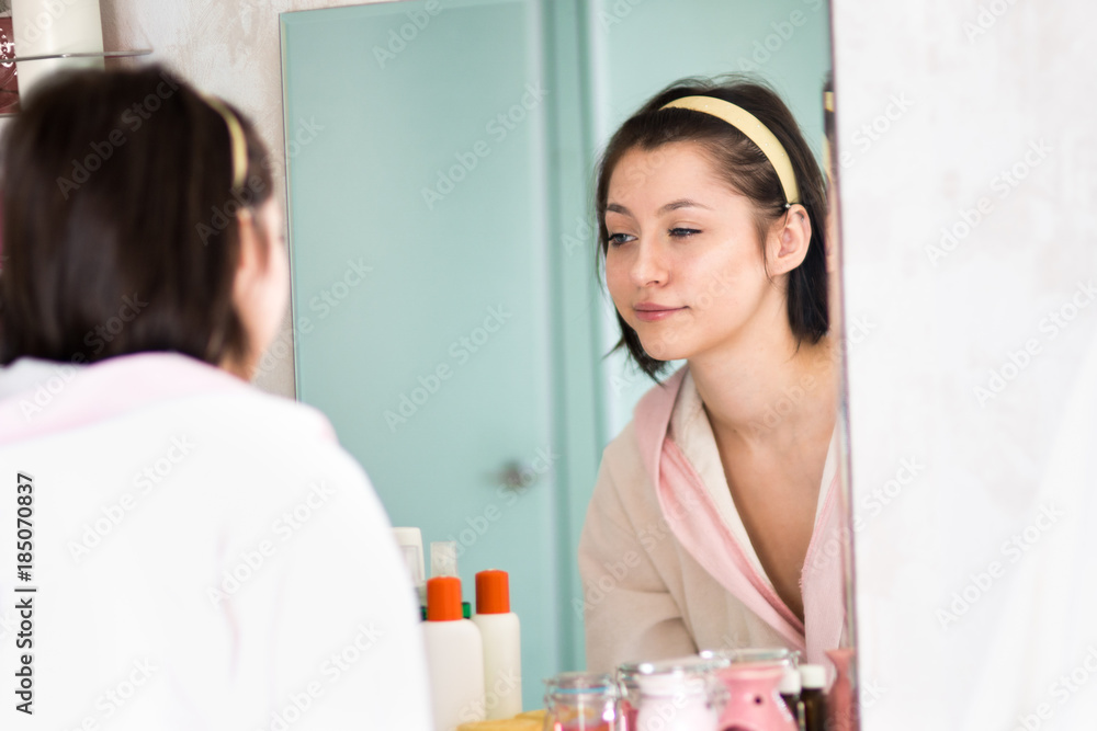 Fototapeta premium young woman in the bathroom yawns and wakes up